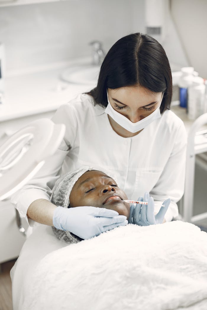 Beautician applying facial treatment to woman in spa clinic, promoting skincare and self-care.